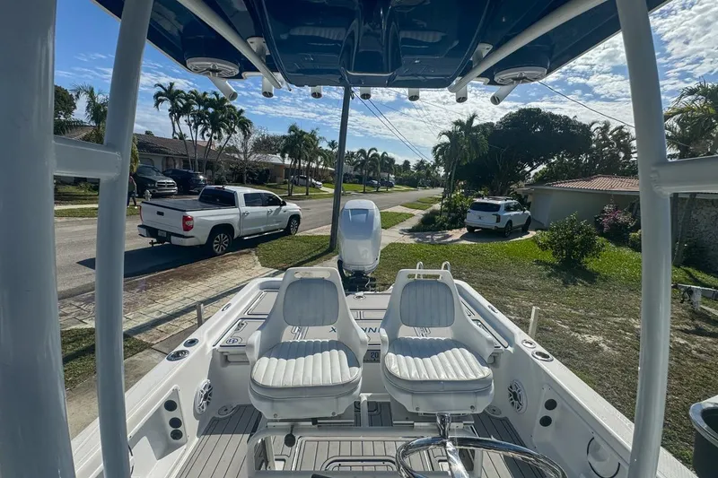 Slide: The Image of 2018 Blue Wave 2400 PureBay boat parked in a suburban neighborhood, showcasing seating and console. - 50