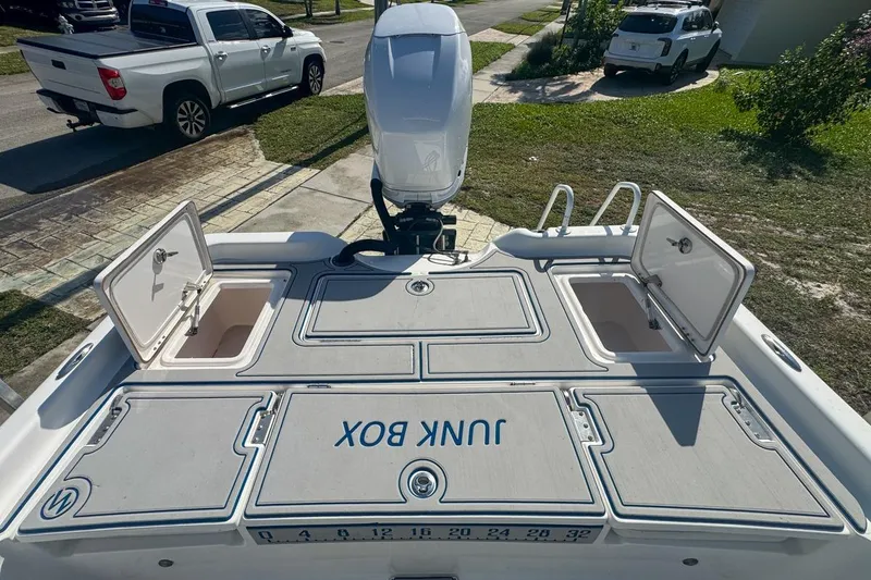 Slide: The Image of 2018 Blue Wave 2400 PureBay boat with open storage compartments on a driveway. - 54