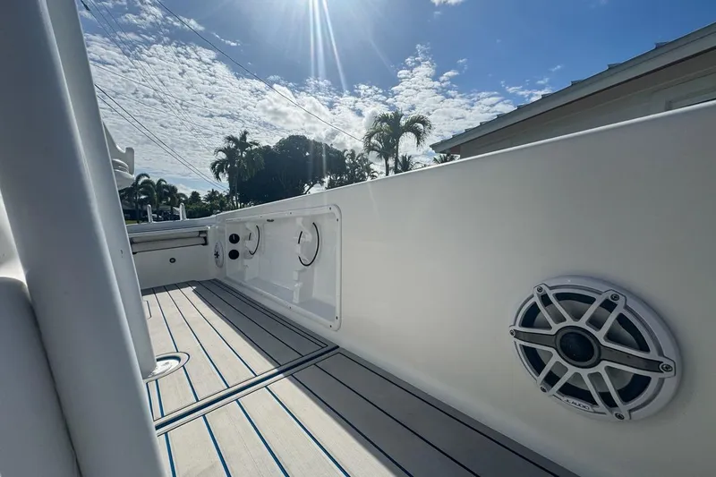 Slide: The Image of 2018 Blue Wave 2400 PureBay boat interior with speaker, under sunny sky. - 61