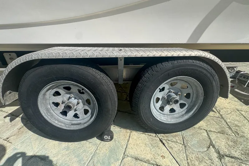 Slide: The Image of Trailer wheels of a 2018 Blue Wave 2400 PureBay boat on a sunny day. - 79