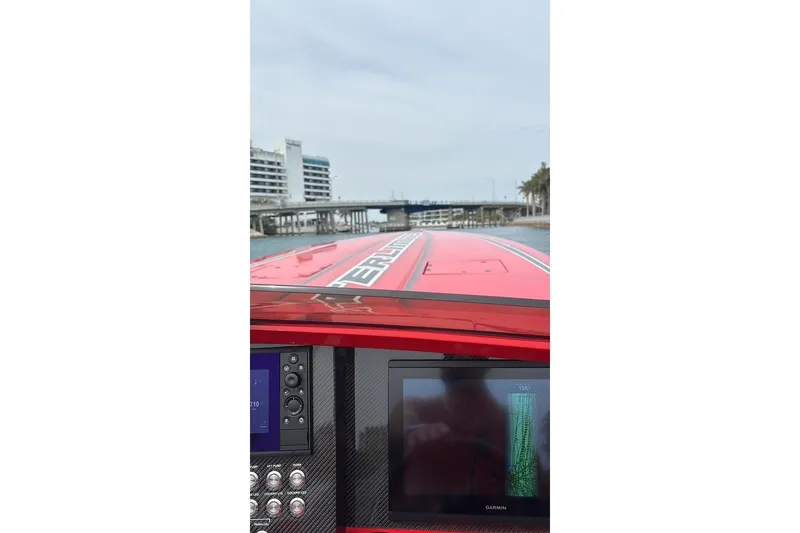 Slide: The Image of 2022 Outerlimits SL41 boat dashboard with navigation screen, cruising near a bridge. - 3