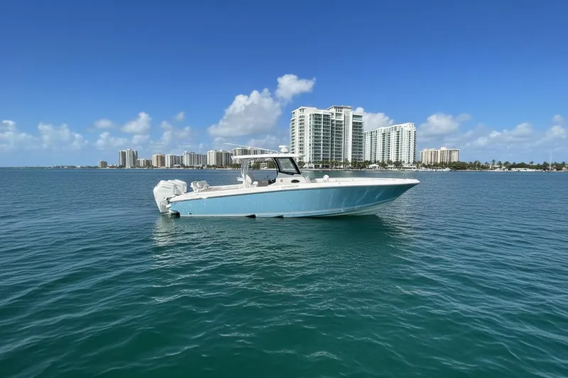 The Image of 2025 Fountain 38 Center Console boat on calm ocean with city skyline backdrop. - 0