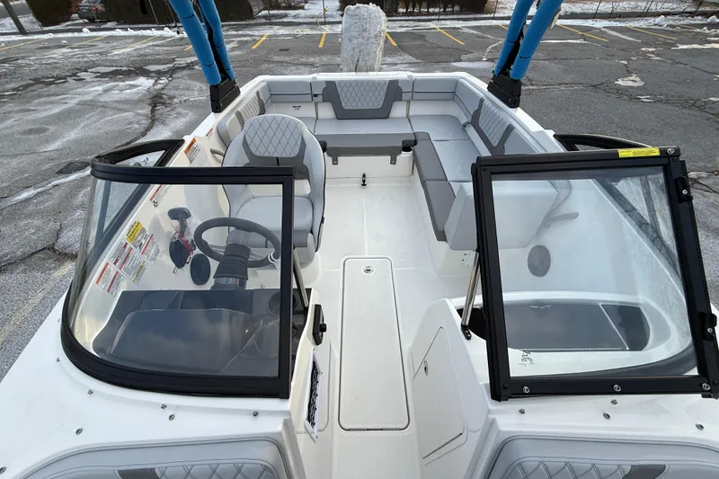 Slide: The Image of 2026 Bayliner VR4 Bowrider OB interior with seating and steering wheel in a parking lot. - 12
