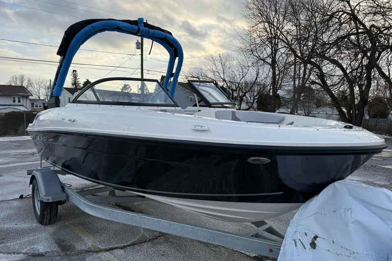 Slide: The Image of 2026 Bayliner VR4 Bowrider OB on trailer, parked outdoors, overcast sky. - 2