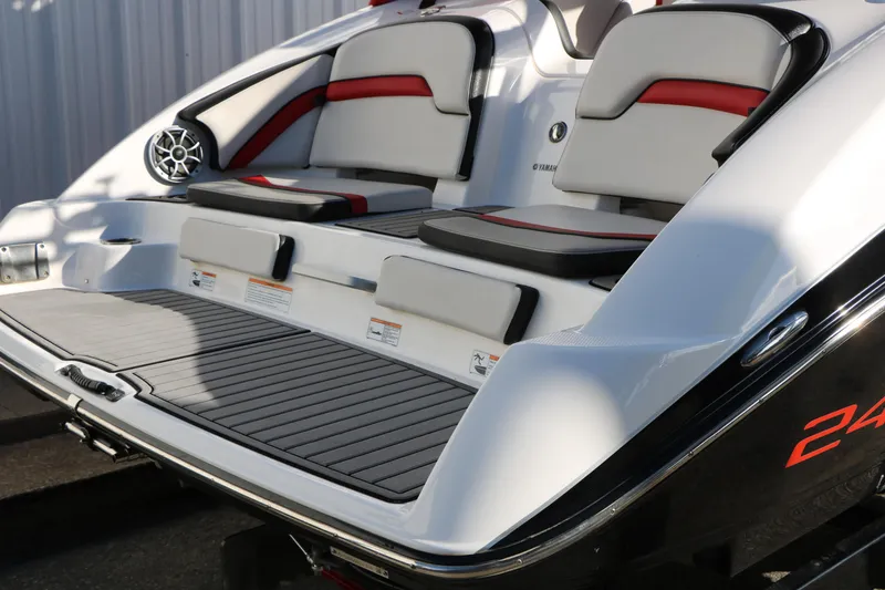 Slide: The Image of 2018 Yamaha Boats 242X E-Series rear seating and deck, featuring sleek design and comfortable cushions. - 5