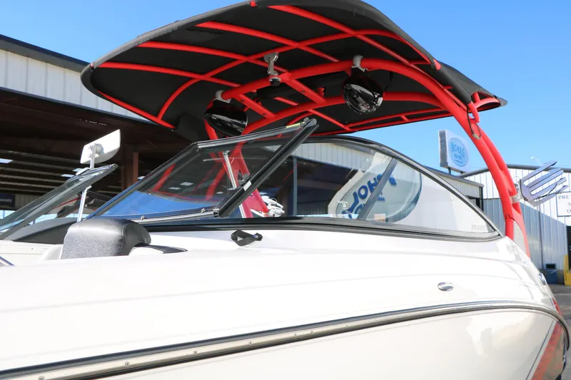 Slide: The Image of 2018 Yamaha Boats 242X E-Series with red wakeboard tower, docked outdoors. - 57
