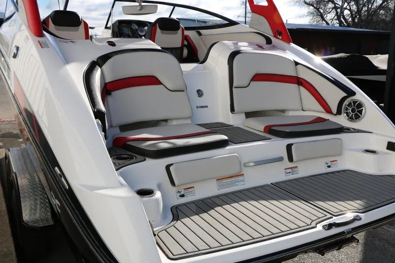 Slide: The Image of 2018 Yamaha Boats 242X E-Series interior with red and black accents, showcasing seating and deck. - 9