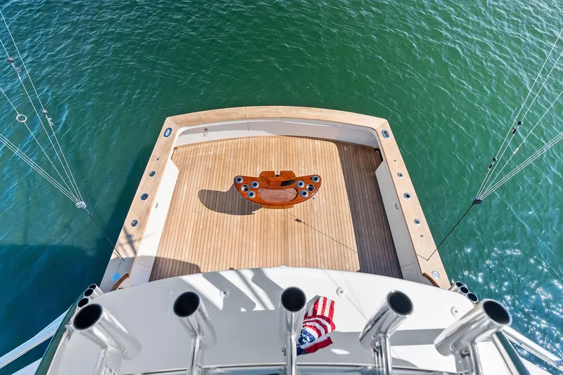 Slide: The Image of Rybovich Sportfish 2000 boat deck with fishing rod holders, overlooking calm water. - 12