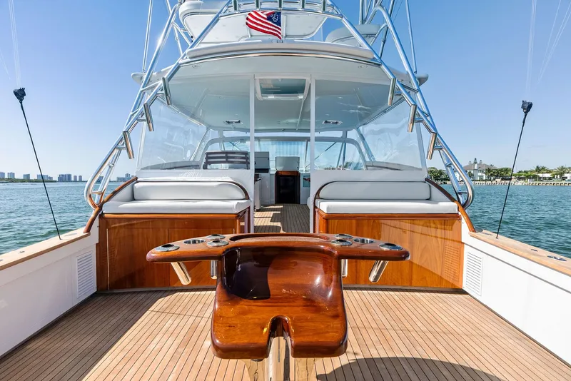 Slide: The Image of 2000 Rybovich Sportfish yacht with wooden deck and American flag, docked on calm waters. - 19