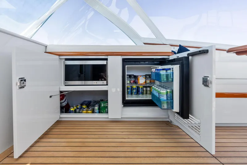 Slide: The Image of 2000 Rybovich Sportfish yacht interior with open cabinets and stocked mini fridge. - 31
