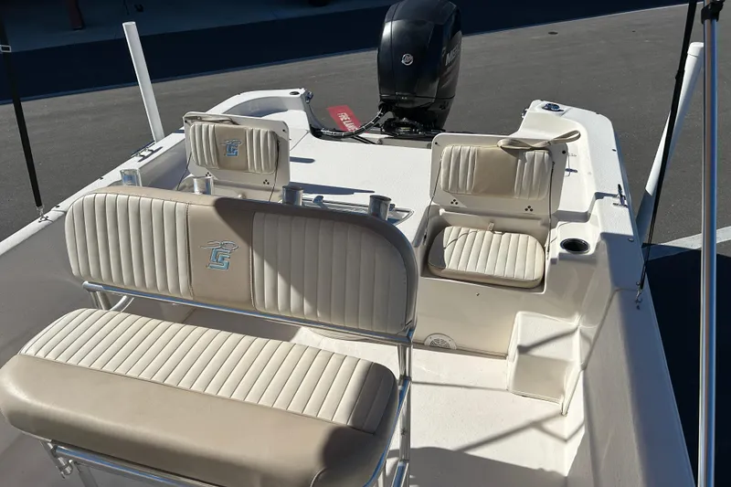 Slide: The Image of 2017 Carolina Skiff 258 DLV boat interior with seating and motor, docked on pavement. - 11