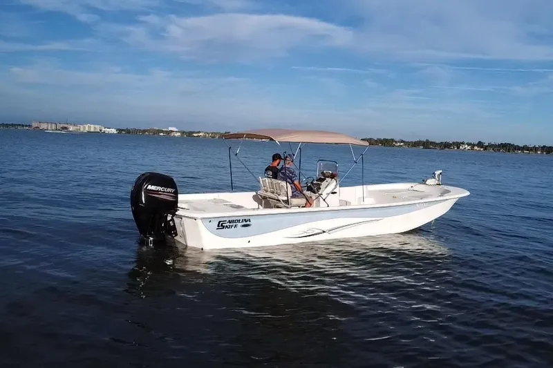 Slide: The Image of 2017 Carolina Skiff 258 DLV boat on calm water with Mercury outboard motor. - 19