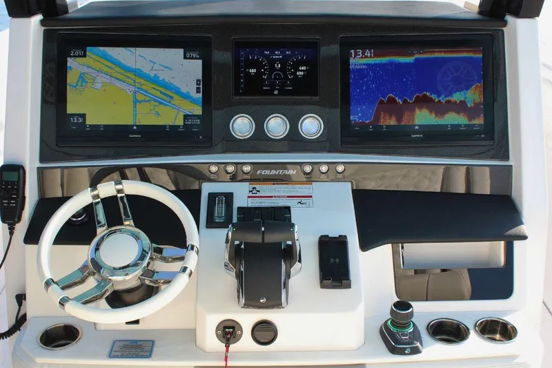 Slide: The Image of 2025 Fountain 38 SCX boat dashboard with navigation screens and controls. - 14