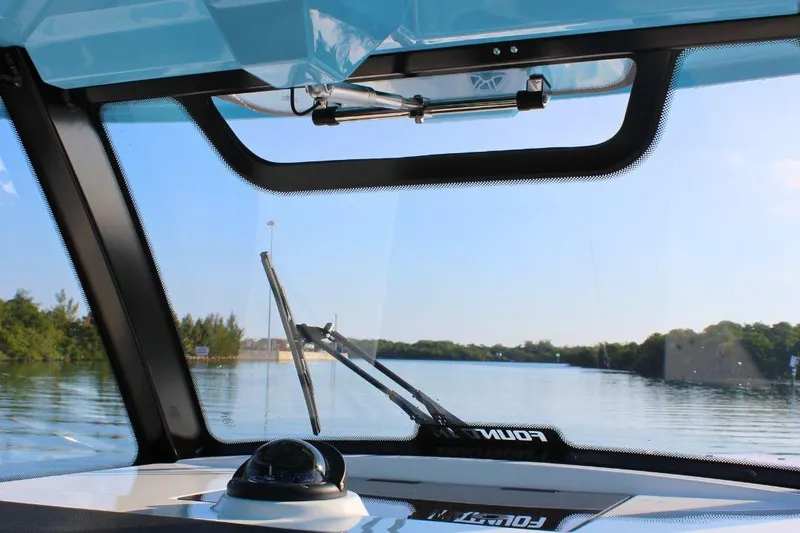 Slide: The Image of Interior view from a 2025 Fountain 38 SCX boat, overlooking calm waters and lush greenery. - 18