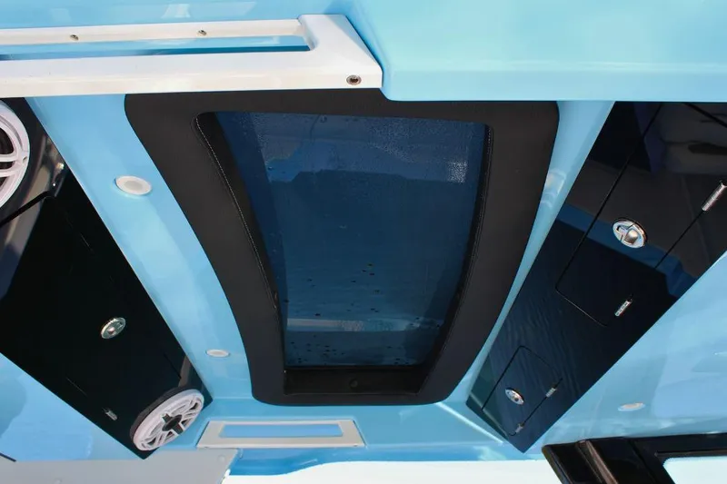 Slide: The Image of 2025 Fountain 38 SCX boat interior with blue ceiling, speakers, and storage compartments. - 19