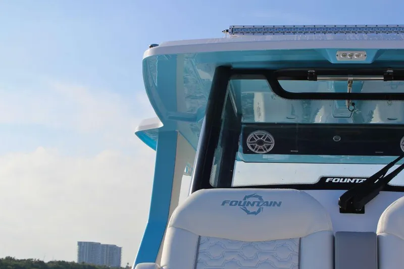 Slide: The Image of 2025 Fountain 38 SCX boat, rear view with logo and speakers, under clear sky. - 28