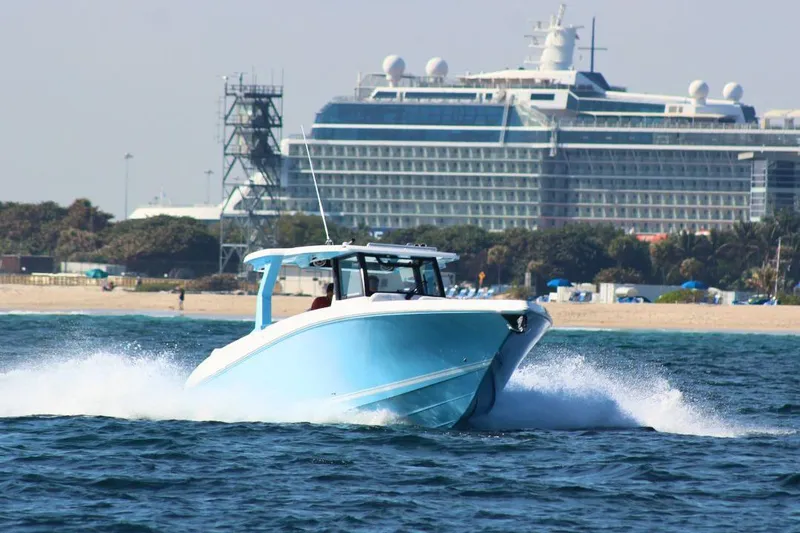 Slide: The Image of 2025 Fountain 38 SCX boat cruising near a large cruise ship in open water. - 4