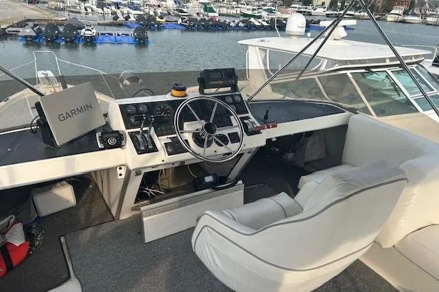 Slide: The Image of 1990 Bayliner 3888 Motoryacht helm with Garmin navigation, docked at marina. - 22