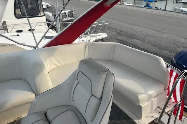 Slide: The Image of 1990 Bayliner 3888 Motoryacht with white seating on deck, docked at marina. - 23