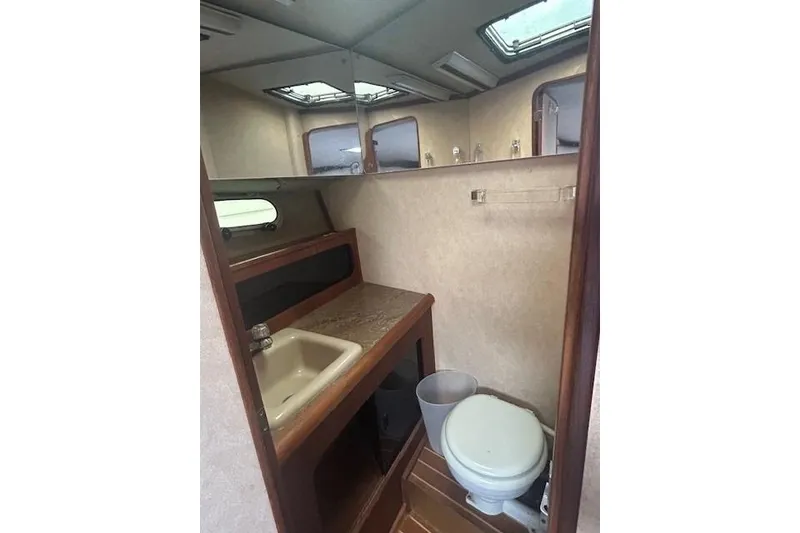 Slide: The Image of 1990 Bayliner 3888 Motoryacht bathroom with sink, toilet, and mirror. - 26