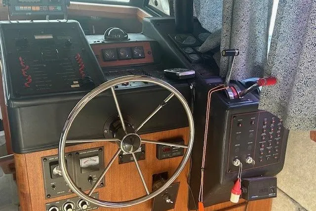 Slide: The Image of 1990 Bayliner 3888 Motoryacht helm with steering wheel and control panel. - 34