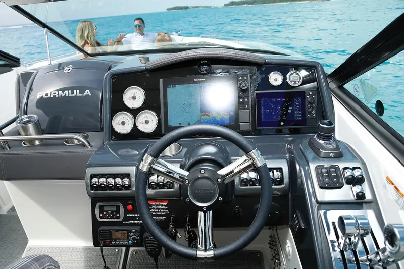Slide: The Image of Manufacturer Provided Image: 2025 Formula 350 Crossover Bowrider I/O dashboard with ocean view and passengers. - 2