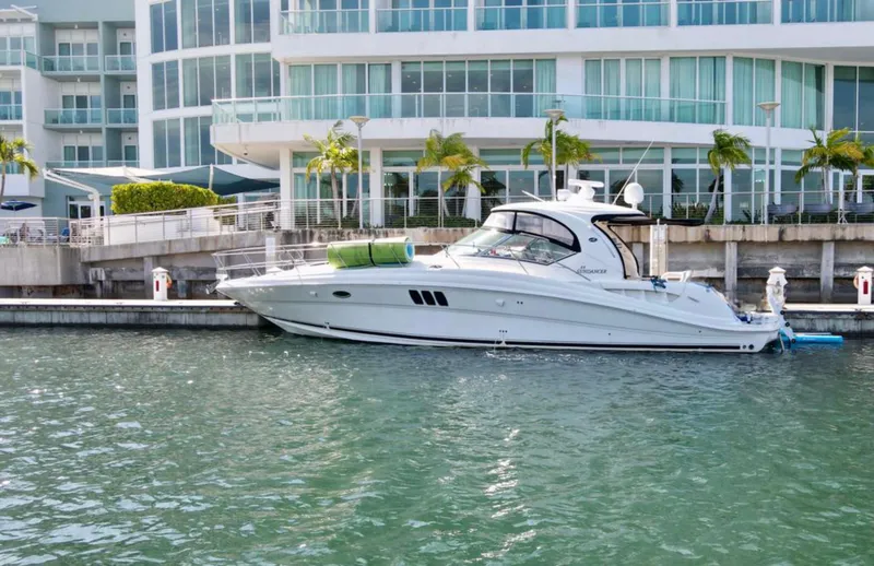 The Image of 2007 Sea Ray 44 Sundancer yacht docked near modern waterfront buildings. - 0