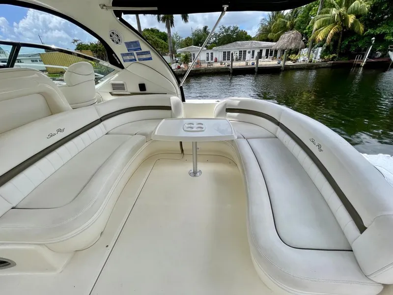 Slide: The Image of 2007 Sea Ray 44 Sundancer boat interior with white seating and table by the water. - 12