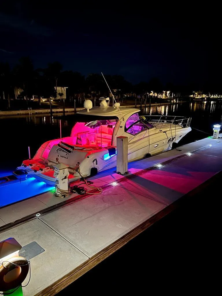 Slide: The Image of 2007 Sea Ray 44 Sundancer yacht docked at night with vibrant LED lighting. - 15