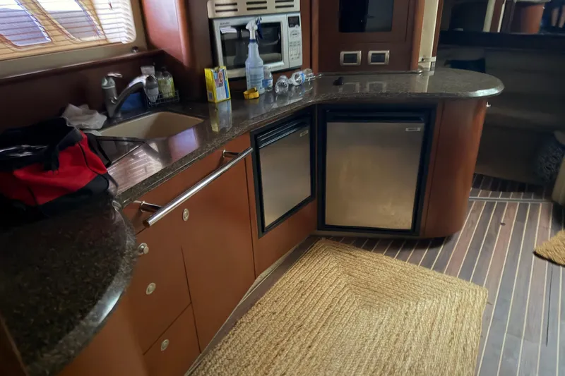 Slide: The Image of 2007 Sea Ray 44 Sundancer yacht kitchen with sink, mini-fridge, and microwave. - 45
