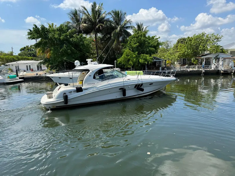 Slide: The Image of 2007 Sea Ray 44 Sundancer yacht cruising on a calm river with lush greenery. - 8