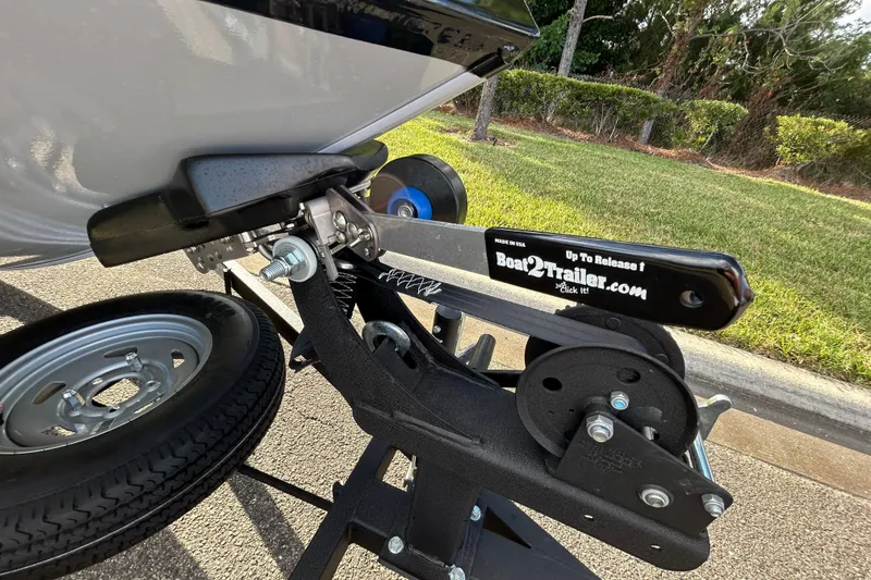 Slide: The Image of 2026 Tracker Pro 170 boat trailer hitch with Boat2Trailer mechanism, parked on pavement. - 12