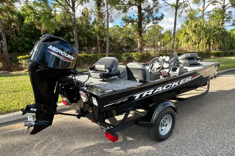 Slide: The Image of 2026 Tracker Pro 170 boat with Mercury engine on a trailer, parked outdoors. - 2