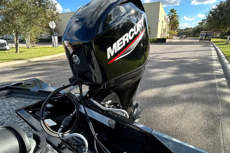 Slide: The Image of 2026 Tracker Pro 170 boat with Mercury outboard motor in a sunny parking lot. - 5