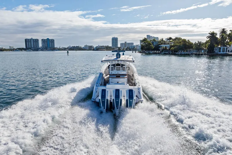 Slide: The Image of 2023 HCB 42 Lujo boat cruising on a sunny waterfront with city skyline. - 10