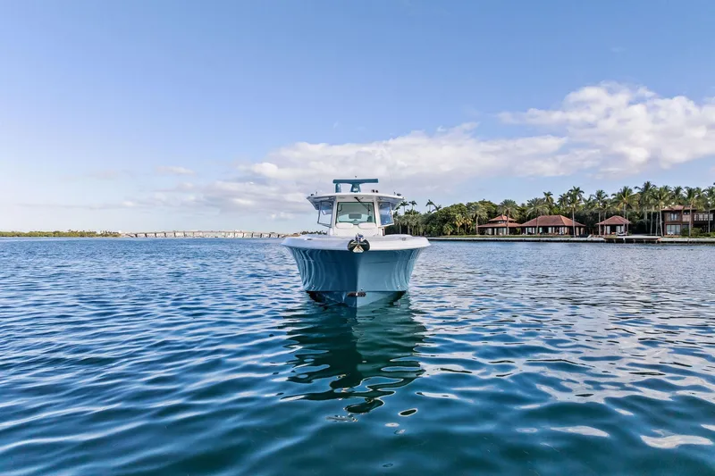 Slide: The Image of 2023 HCB 42 Lujo boat on calm water with city skyline in background. - 2