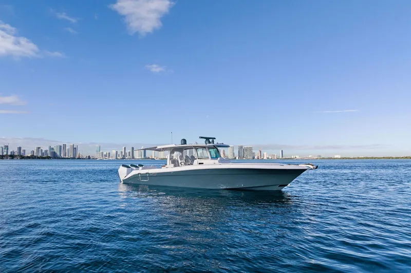 Slide: The Image of 2023 HCB 42 Lujo boat on calm water near tropical shoreline. - 3
