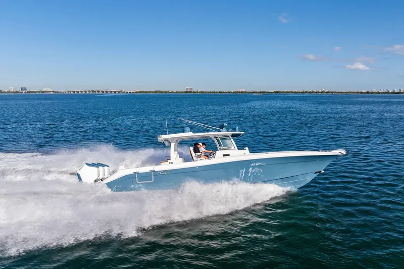 Slide: The Image of 2023 HCB 42 Lujo boat cruising on open water under clear blue skies. - 8