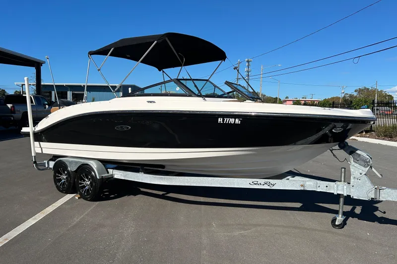 The Image of 2018 Sea Ray SPX 210 Outboard boat on trailer, black and white design, sunny day. - 1
