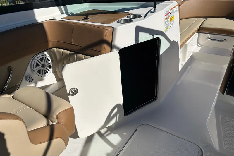 Slide: The Image of 2018 Sea Ray SPX 210 Outboard interior with open storage compartment and cup holders. - 15