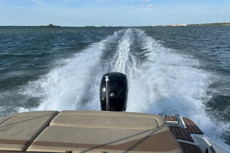 Slide: The Image of 2018 Sea Ray SPX 210 Outboard cruising on open water, leaving a wake behind. - 20