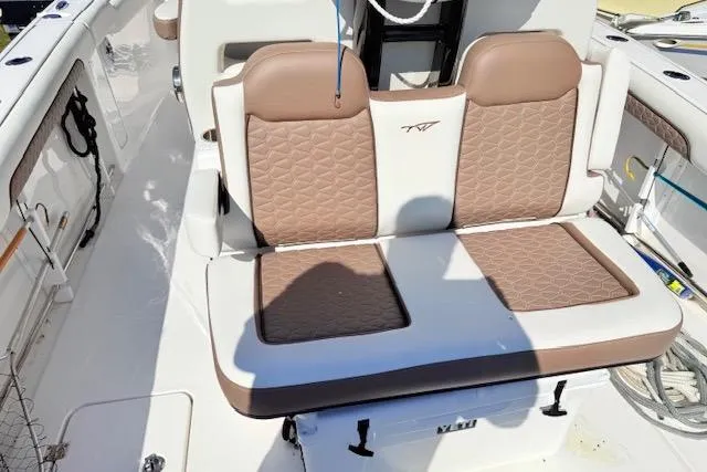 Slide: The Image of 2026 Tidewater 302 CC Adventure boat with brown and white cushioned seating. - 5