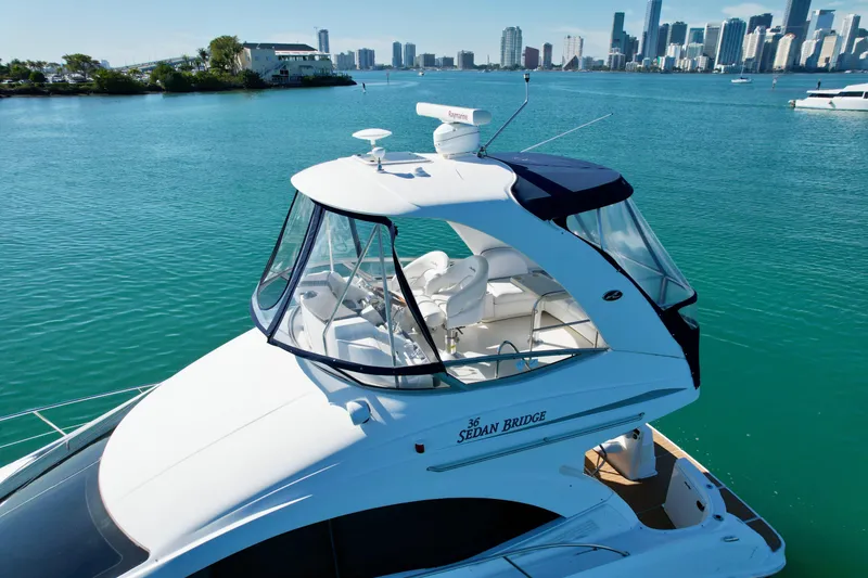 Slide: The Image of 2007 Sea Ray 360 Sedan Bridge yacht on turquoise water with city skyline. - 14