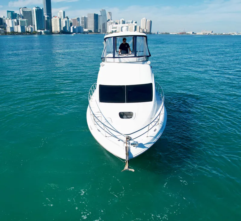 Slide: The Image of 2007 Sea Ray 360 Sedan Bridge yacht on turquoise water with city skyline in background. - 18