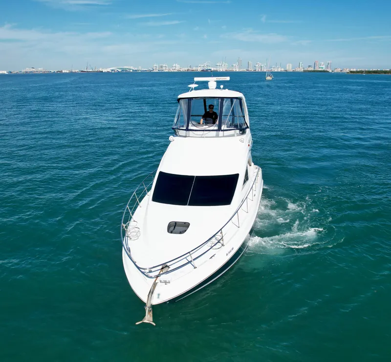 Slide: The Image of 2007 Sea Ray 360 Sedan Bridge cruising on open water with city skyline in background. - 23