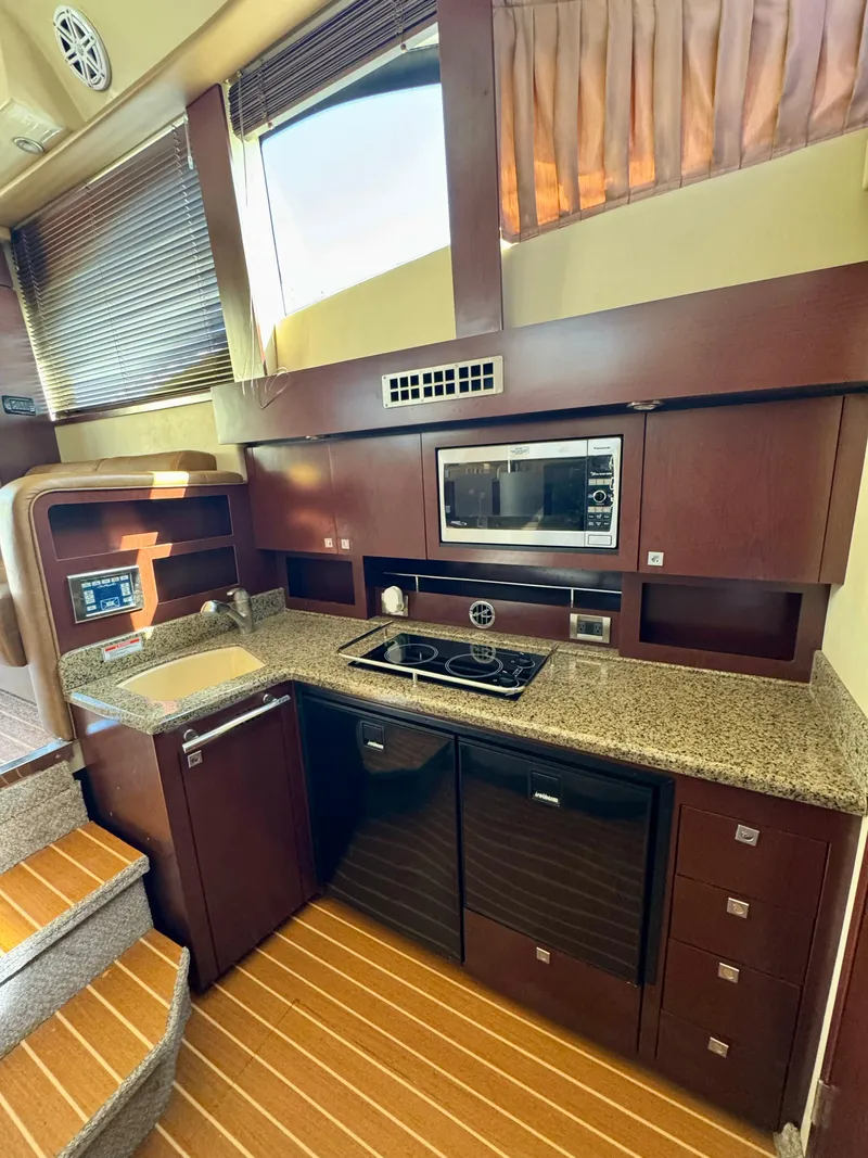 Slide: The Image of 2007 Sea Ray 360 Sedan Bridge kitchen with modern appliances and wood cabinetry. - 30
