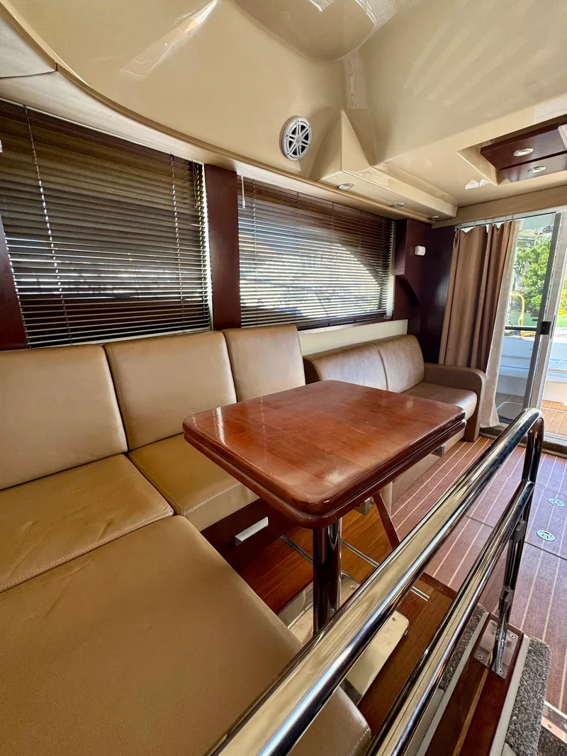 Slide: The Image of 2007 Sea Ray 360 Sedan Bridge interior with beige seating and wooden table. - 31