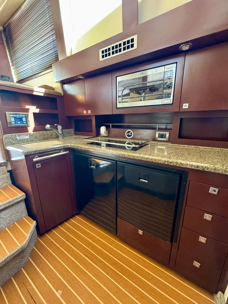 Slide: The Image of 2007 Sea Ray 360 Sedan Bridge kitchen with modern appliances and wooden cabinetry. - 32
