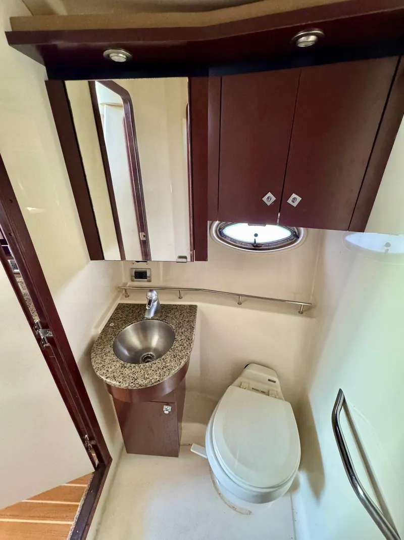 Slide: The Image of 2007 Sea Ray 360 Sedan Bridge bathroom with sink, toilet, and wooden cabinetry. - 35