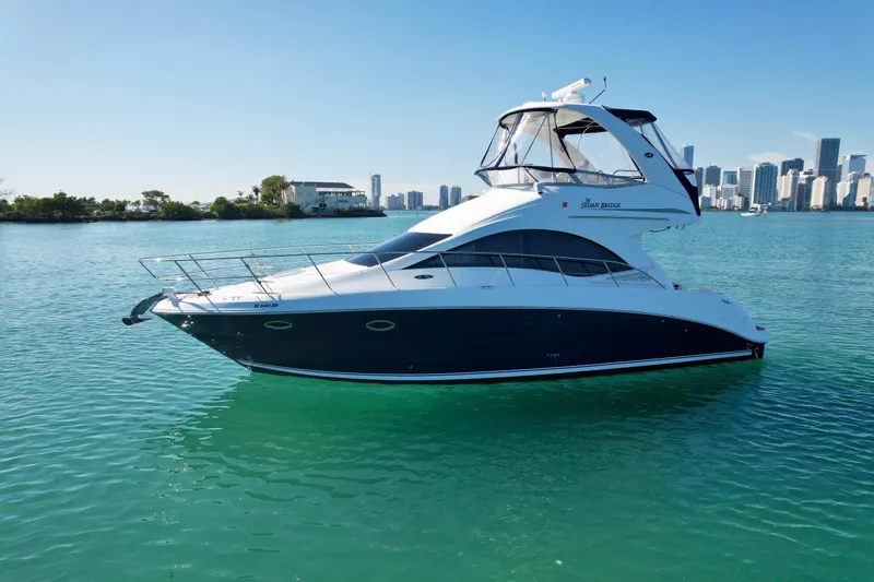 Slide: The Image of 2007 Sea Ray 360 Sedan Bridge yacht on calm water with city skyline. - 4